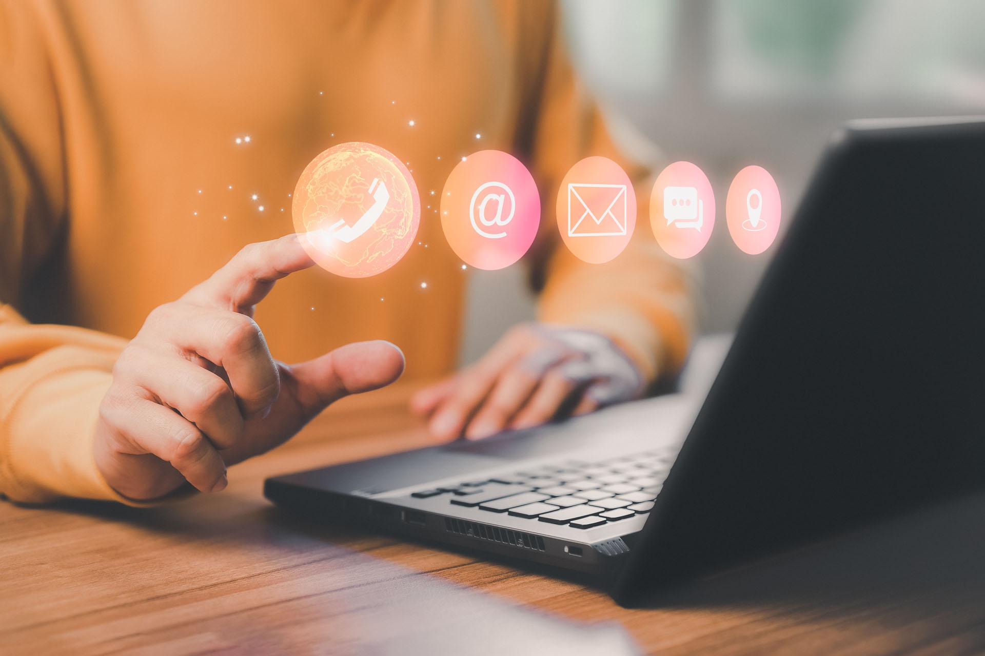 Man using a computer laptop and touching on technology virtual screen contact icons