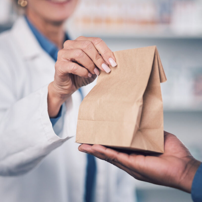 Woman, pharmacist and hands with medication for patient